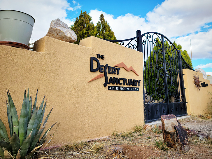 A photo I took that highlights the name of the business on a terra cotta fence with an iron gate.