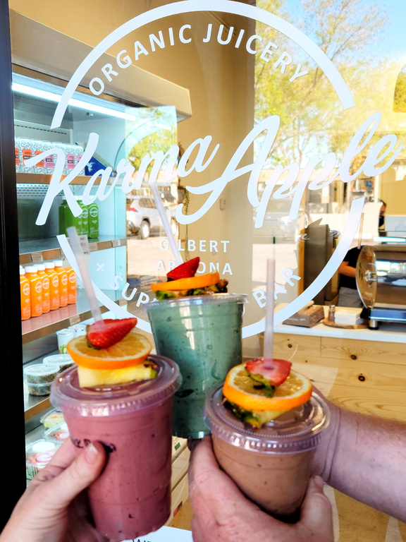 Social media photo I took showing colorful smoothies being held in front of the store logo.